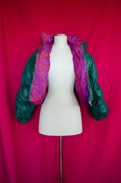 Reversible crop waisted puffer jacket with custom print designed by Samm Lee. Two pockets, windbreaking capabilities. Biodegradable nylon outer shell, recycled PET bottle thread inner shell, and recycled poly down foam. MC (5'4", 162cm) wears a size S Care instructions: Machine wash cold. Hang dry or machine dry. Do not bleach. Green Quilted Puffer Jacket For Streetwear, Green Nylon Puffer Jacket With Padded Collar, Green Fitted Puffer Outerwear, Gem Tones, Winter Puffer Jackets, Pet Bottle, Puffer Jacket, Capsule Wardrobe, Biodegradable Products