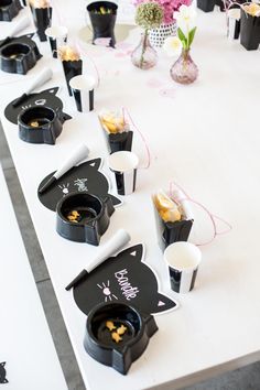 black and white desserts are lined up on a table with pink flowers in vases