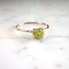 "Romantic and timeless, contemporary yet feminine. A beautiful faceted Peridot shines within a classic 4 prong setting. Super clean and stunning. These pictures just don't do it justice...Raised just enough to pair with our skinny stacking bands. Perfect for august birthdays or for mothers to start a birthstone collection of their kids Natural Peridot Round, 5mm Lime green, Kelly Green Slightly included - very clean Made to Order - Production time is 2-3 weeks Order :: Choose your G O L D - avai Elegant Peridot Birthstone Ring With Prong Setting, Elegant Lime Green Birthstone Promise Ring, Elegant Peridot Birthstone Ring, Yellow Gold Peridot Solitaire Birthstone Ring, Peridot Birthstone Ring Round Cut, Elegant Peridot Solitaire Ring, Elegant Solitaire Peridot Ring, Peridot Birthstone Ring For May, Peridot Solitaire Birthstone Ring