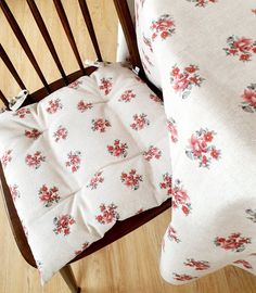 a chair with a pillow on top of it next to a wooden table and floor