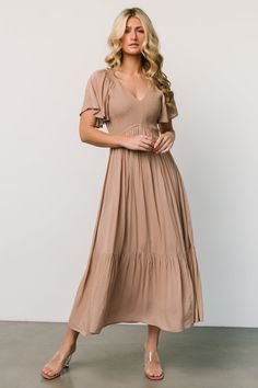 Experience the epitome of bohemian chic with our maxi Rayon dress, featuring a smocked bodice, a flattering V neckline, and delicate short flutter sleeves. This dress effortlessly combines comfort and style, making it a must-have for any fashion-forward individual seeking a versatile and trendy wardrobe staple. Staple Dress, Baltic Born, Photoshoot Dress, Tan Dresses, Maxi Styles, Rayon Dress, Pleated Maxi Dress, Pleated Maxi, Velvet Fashion