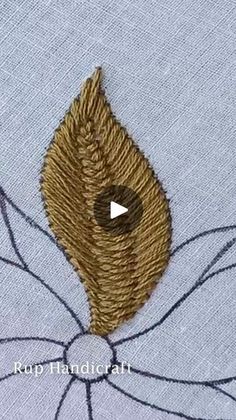 a close up of a piece of cloth with an embroidered leaf on it