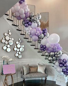 the staircase is decorated with purple and silver balloons