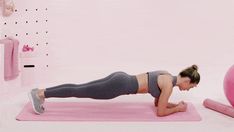 a woman doing push ups on a pink exercise mat