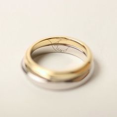 two wedding rings sitting on top of each other