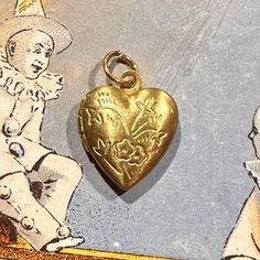 ONE vintage tiny locket in a heart shape with a floral motif. Each old stock locket has been slightly hand buffed for a warm, buttery patina. A diminutive 5/8" when closed, this can possibly hold tiny photos inside. Each is unique in patina and small imperfections. COLOR: yellow brass SIZE: just under 5/8" tall and 1/2" wide CONDITION: vintage old stock ONE TINY LOCKET Antique Heart Locket Necklace For Memorial, Heart-shaped Vintage Locket Necklace For Memorials, Heart Locket Necklace With Vintage Charm For Memorial, Heart Shaped Memorial Locket Necklace With Vintage Charm, Memorial Heart Locket Necklace With Vintage Charm, Antique Heart Charm Locket For Valentine's Day, Antique Heart Charm Locket Necklace For Valentine's Day, Antique Locket Necklace With Heart Charm For Valentine's Day, Victorian Locket Necklace For Valentine's Day