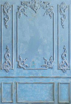 a blue door with ornate carvings on the front and side panels, painted in light blue