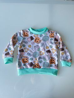 Keep your little one cozy and stylish with our Unisex Fall and Halloween Kids Sweater! This adorable orange sweater is perfect for the autumn season, featuring charming pumpkin and bat designs that celebrate the spooky spirit of Halloween. Made with soft, high-quality fabric, it ensures comfort and warmth for your baby boy or girl during chilly fall days. Ideal for baby shower gifts or adding a festive touch to your toddler's wardrobe, this sweater is designed with both style and practicality in Long Sleeve Tops For Fall Playtime, Cute Long Sleeve Sweater For Playtime, Unisex Long Sleeve Sweatshirt For Fall, Playful Crew Neck Fall Sweater, Playful Crew Neck Sweater For Fall, Playful Long Sleeve Sweater For Fall, Fall Playtime Crew Neck Tops, Cute Long Sleeve Orange Top, Playful Cotton Sweater For Fall