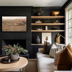 a living room filled with furniture and a fire place in front of a wall mounted book shelf