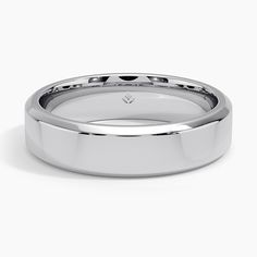 a white gold wedding ring on a plain surface