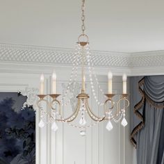 a chandelier hanging from the ceiling in a room with curtains and drapes