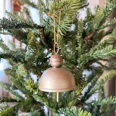 a bell hanging from the top of a christmas tree