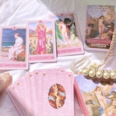 a table topped with lots of pink cards and other items on top of a white sheet