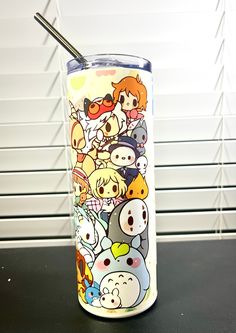 a cup that has some cartoon characters on it with a straw sticking out of it