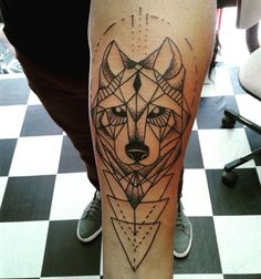 a person with a tattoo on their leg that has a wolf head in the middle