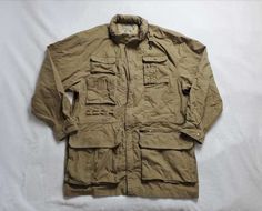 BRAND: Banana Republic DESCRIPTION: Probably the most amazing vintage safari jacket I've seen. Looks to be late 80s or very early 90s based on the tag Men's size M, although please go by measurements as things fit differently now. This seems like it would be a very baggy M. One Harrison St. vintage BR tag - they moved to that location in San Francisco the late 80s  Hidden hood Too many pockets to count Hidden drawcord waist 100% cotton Good vintage condition: There looks to be a pen or pencil ma Vintage Parka With Flap Pockets For Outdoor, Vintage Outdoor Parka With Flap Pockets, Casual Hunting Utility Jacket With Multiple Pockets, Vintage Khaki Parka For Outdoor, Casual Parka With Pockets For Hunting, Casual Hunting Parka With Pockets, Casual Khaki Windbreaker For Hunting, Vintage Khaki Parka With Flap Pockets, Vintage Utility Jacket With Cargo Pockets For Streetwear