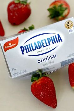 a carton of philadelphia cheese next to strawberries