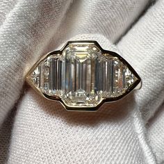 an antique diamond ring is shown on a white cloth