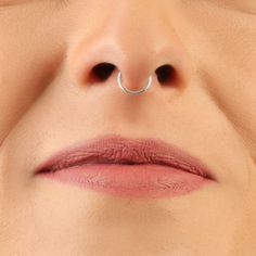 a woman's nose with a nose ring on top of her nose and the bottom part of her lip