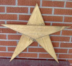 a wooden star hanging on a brick wall