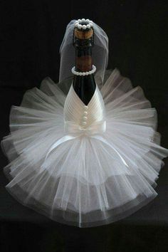 a bottle of wine in a tutu with a bride's veil on top