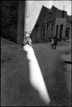 an old black and white photo of a person swinging a baseball bat at a ball