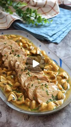 a plate full of pasta with sauce and meat on it, sitting on a table