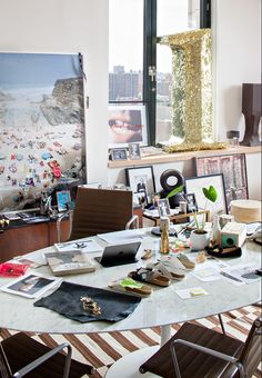 a dining room table is covered with pictures and other things in front of a large window