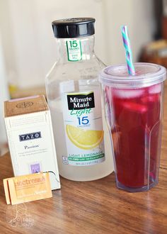 a drink and some other items on a wooden table with a bottle of liquid next to it