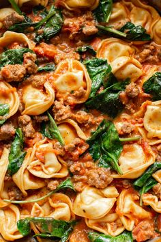 pasta with spinach and meat sauce in a pan