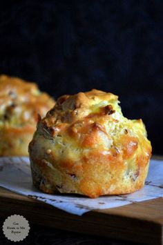 two muffins sitting on top of a wooden cutting board