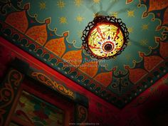 the ceiling is decorated with intricate designs and lightshades, including a chandelier