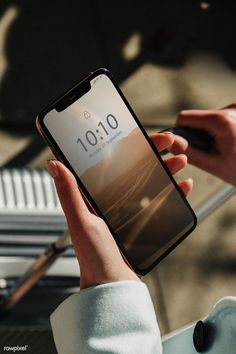 a person holding an iphone in their hand with the screen showing 10 01 on it