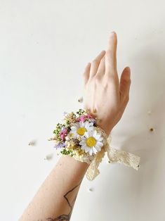 a person's arm with flowers on it and a wristband wrapped around them