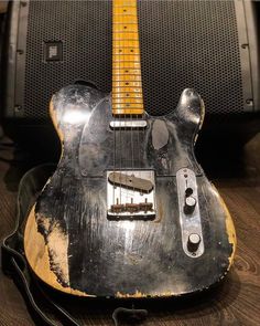 an old guitar sitting on top of a wooden table