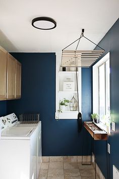 a laundry room with blue walls and white appliances on the counter top, next to a washer and dryer