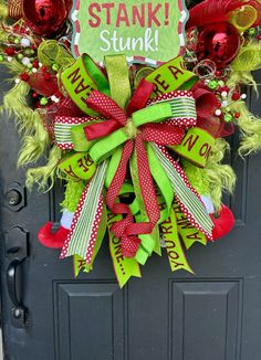 a green and red christmas wreath with the words stank stink on it's front door