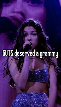 a girl in a purple outfit singing into a microphone with the caption guts deserved a granny