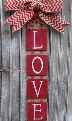 a red and white door hanger with the word love on it