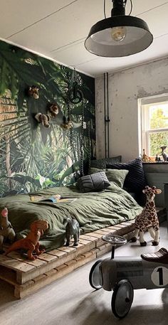 a child's bedroom decorated with jungle wallpaper and toy animals on the bed