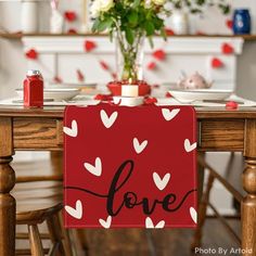 the table is set with plates, cups and vases for valentine's day