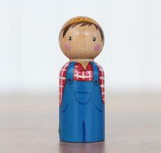 a wooden toy with a red and white checkered shirt on it's chest