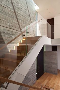 the stairs in this modern house are made of wood and glass