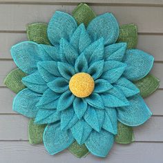 a blue and green flower on the side of a house