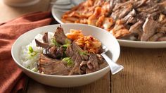 two white bowls filled with meat and rice