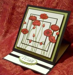 a close up of a card with red flowers on the front and back of it