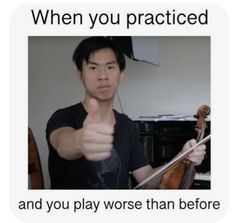 a man giving the thumbs up while holding a violin in one hand and an instrument in the other