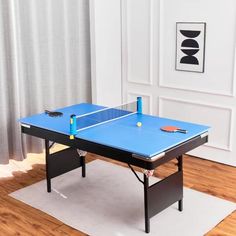 a ping pong table in the middle of a room with a rug on the floor