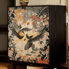 the cabinet is decorated with exotic flowers and birds on it's side paneling