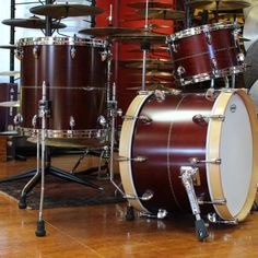 a drum set sitting on top of a hard wood floor next to other musical instruments